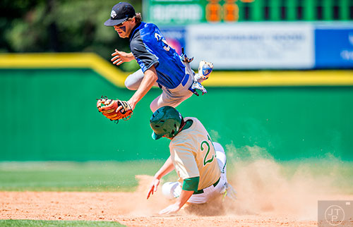Locust Grove's Trevor Sellers (3) flies intot he air as he collides with Buford's Thames Hudlow (21)) slides into second a little late during the GHSA Class AAAA Championship Baseball Tournament in Buford on Saturday, May 21, 2016.