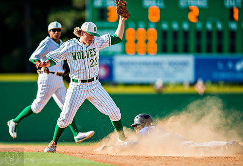 Locust Grove's Odlanier Rodriguez (right) slides into second base safely as Buford's Dillon Lancaster (22) gets the ball late during the final game of the Class AAAA baseball championships in Buford on Monday, May 23, 2016. 