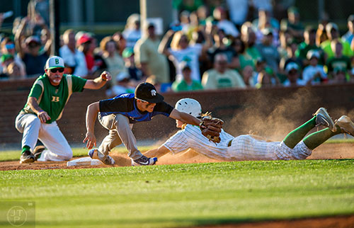 Locust Grove's Nolan Crisp (left) stretches for the out at third as Buford's Brandon Marsh slides to tag the base during the final game of the Class AAAA baseball championships in Buford on Monday, May 23, 2016. The original call was safe at base which was then overturned. 