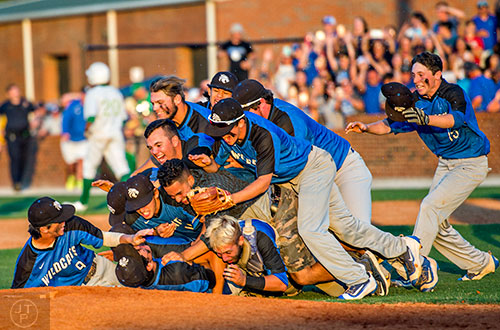 Locust Grove piles on top of relief pitcher Odlanier Rodriguez (bottom center) after the last out of the final game of the Class AAAA baseball championships in Buford on Monday, May 23, 2016. 