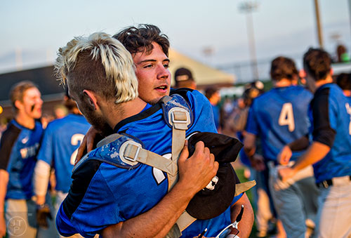 Locust Grove's Trevor Sellers (center) hugs teammate Colton Bailey after defeating Buford 3-1 at the end of the final game of the Class AAAA baseball championships in Buford on Monday, May 23, 2016. 