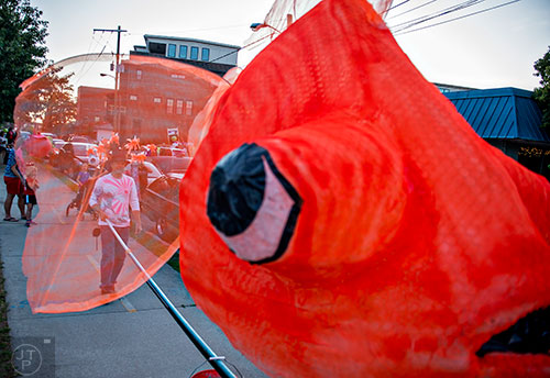 Dave Lind (left) moves his goldfish lantern into position as he waits for the start of the third annual Decatur Lantern Parade on Friday.