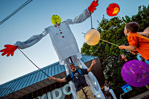 Kids look up at Cameron Ayer (left) as they wait  for the start of the third annual Decatur Lantern Parade on Friday.