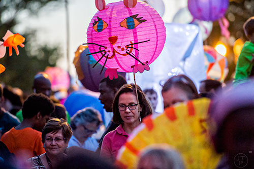 Barbara Herrera (center) holds a cat lantern as she waits for the start of the third annual Decatur Lantern Parade on Friday.