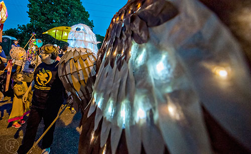 Dianna Watson (left) holds an eagle lantern as she waits for the start of the third annual Decatur Lantern Parade on Friday.