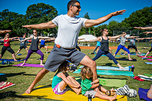 Jean Jacque Credi practices yoga as his children Eve and Edison hang at his feet during the Kirkwood Spring Fling on Saturday.