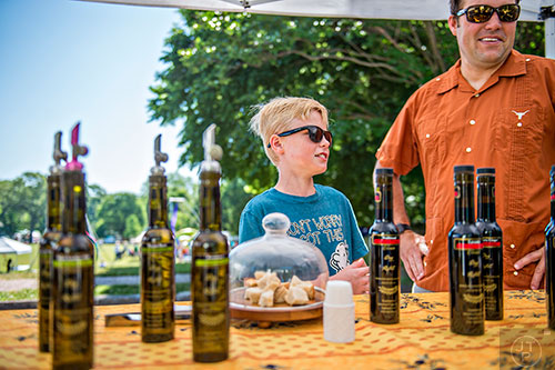 Lyndon Warren and his father David try samples of olive oil during the Kirkwood Spring Fling on Saturday.