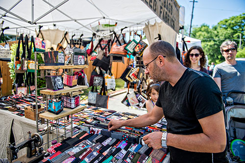 Sammy Brewer (center) checks out wallets at one of the artist booths during the Kirkwood Spring Fling on Saturday.