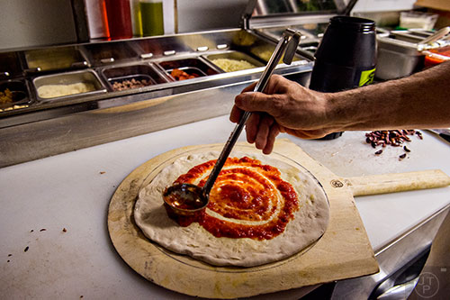 Sauce is applied to the fresh dough at Atwood's in Midtown.
