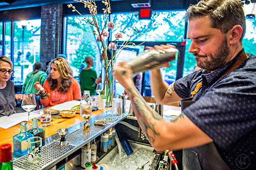 Bartenders create cocktails behind the bar at Brush Sushi Izakaya in Decatur.
