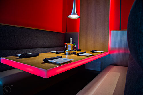 Neon lighting wraps around a table in one of the booths at Cowfish.