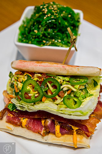 Cowfish serves up the What's Shakin' Tuna Bacon. Seared yellowfin tuna, applewood bacon, iceberg, jalapenos, tomato salsa, Asian slaw and spicy mayo are served between a grilled spring roll wrapper stuffed with kani and sushi rice.
