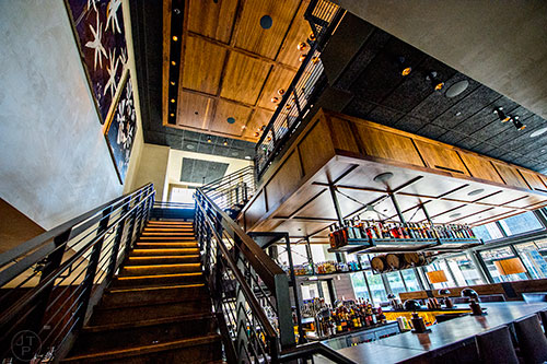 A stairway behind the bar leads to an upper dining room and patio at South City Kitchen in Buckhead.