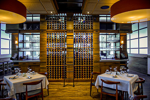 The main dining room at Noble Fin showcasing a floor to ceiling wine rack.