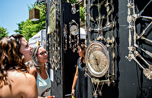 Robin Raffa (center) and her daughter Rebecca check out one of the numerous artist booths during the Decatur Arts Festival on Saturday.