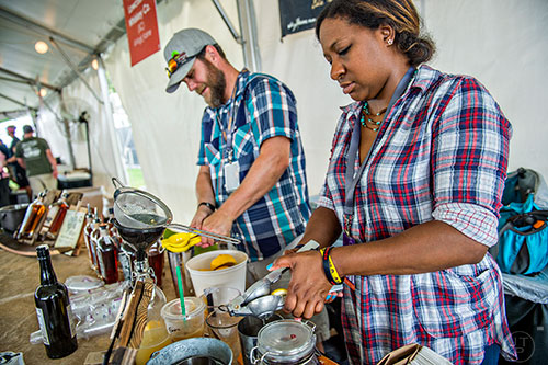 The crew at Virgil Kaine squeeze lemons at the tasting tents in Piedmont Park during the Atlanta Food & Wine Festival on Sunday.