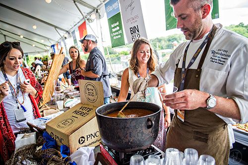 Seafood R'evolution's Payton Warren scoops out a Mississippi styled seafood gumbo at the tasting tents in Piedmont Park during the Atlanta Food & Wine Festival on Sunday.