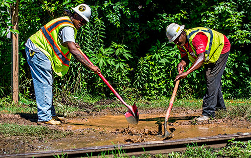 Construction workers remove water and mud along the Atlanta Beltline Eastside Trail extension in Reynoldstown near Kirkwood Ave.
