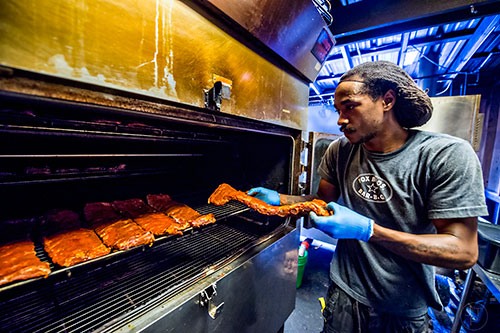 Ribs go in the smoker in the smoke room at Fox Bros. Barbecue off of Dekalb Ave. in Atlanta.