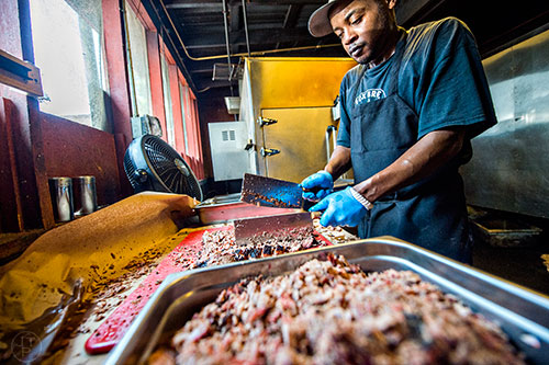 Keeping pace with the lunch crowd sometimes involves using two cleavers to chop meat at Fox Bros. Barbecue in Atlanta.