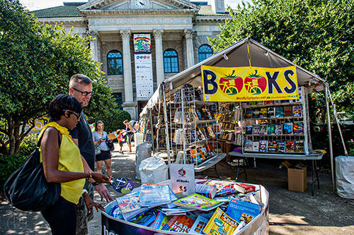 Irene Muturi (left) and Chris Andrews check out some of the books for sale during the Decatur Book Festival on Saturday.