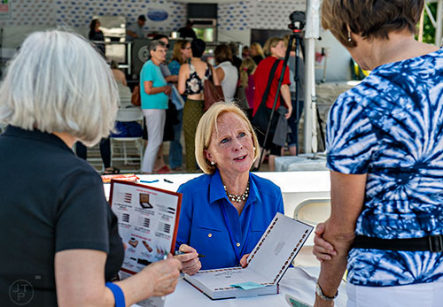 Author Anne Byrn talks to fans as she autographs books during the Decatur Book Festival on Saturday.