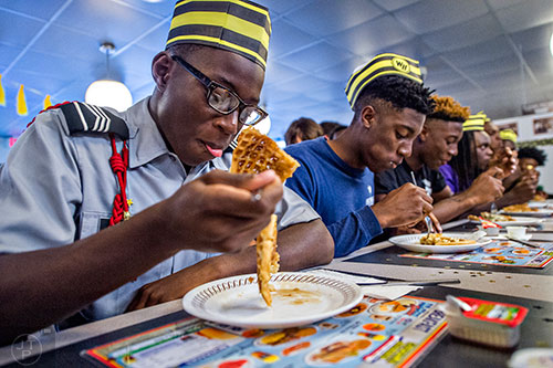 Martize Smith (left) takes the slow and steady approach to the waffle eating contest at the Waffle House off of Decatur Square on Friday.