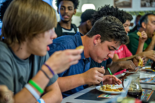 Sam Cooper opts for the fork approach during the waffle eating contest at the Waffle House off of Decatur Square on Friday.