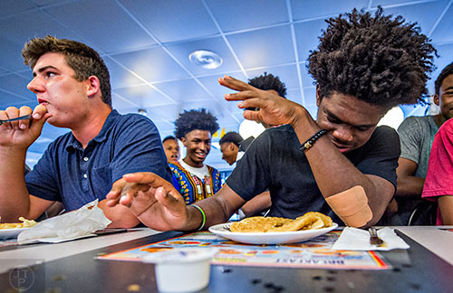 Jeremy Slaughter (right) taps out as Cole Baker continues to eat during the waffle eating contest at the Waffle House off of Decatur Square on Friday.