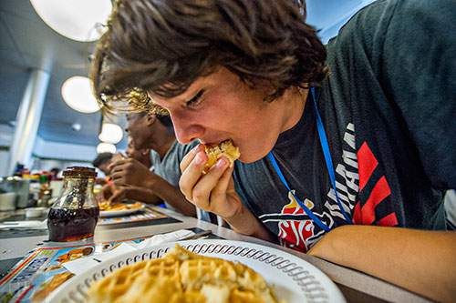 Jacob Poe shoves a waffle into his mouth as the final seconds of the third round tick down during the waffle eating contest at the Waffle House off of Decatur Square on Friday.