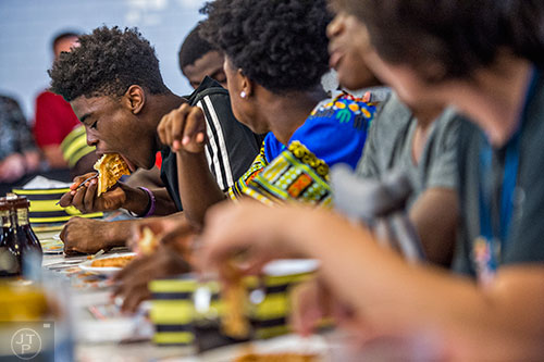 Andre Carter leans over a waffle as he stuffs it in his mouth during the waffle eating contest at the Waffle House off of Decatur Square on Friday.