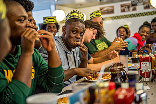 Jonah Wildgoose (center) glances over at Jason McLin as he shoves a waffle into his mouth during the championship round of the waffle eating contest at the Waffle House off of Decatur Square on Friday.