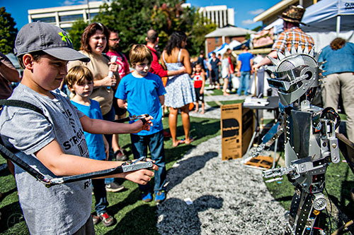 Alex Robinson controls a robot using his arms during the Atlanta Maker Faire in Decatur on Saturday.