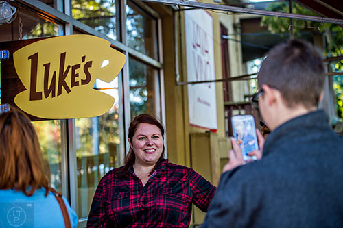 Customers take photos in front of the Luke's sign at JavaVino in Atlanta during the Netflix Gilmore Girls Luke's Diner Takeover on Wednesday morning.