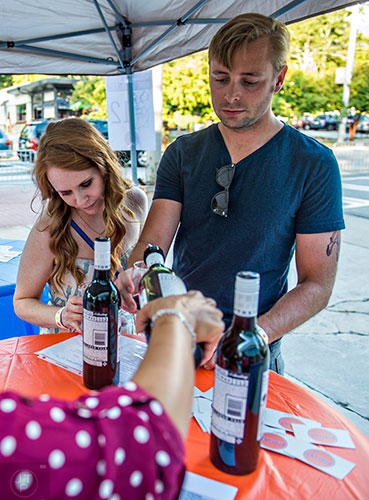 Brooke Brown (left) and her husband Lauren have their glasses filled with wine during the Kirkwood Wine Stroll on Friday.