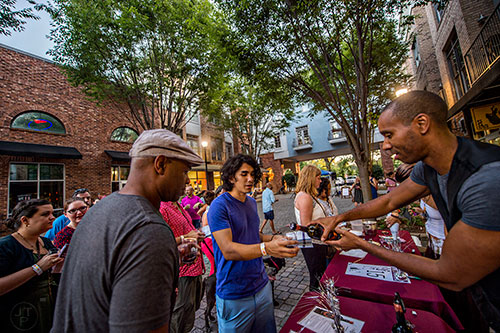 Kevin Wilson (right) pours wine for Jin Lee and Cris Gray during the Kirkwood Wine Stroll on Friday.