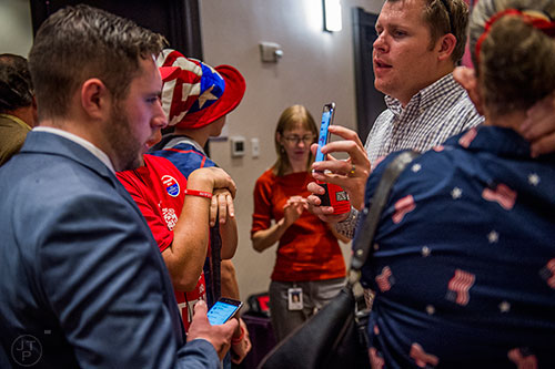 Steve Collier (right) shows polling results to Skylar King (left) using his phone during the GOP Election Party at the Tech Center Doubletree Hotel in Denver on Tuesday, November 8, 2016.
