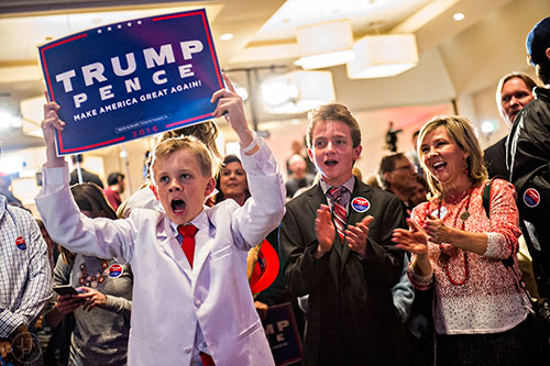 Dalton Walker (left) cheers as he holds up a Trump/Pence sign during the GOP Election Party at the Tech Center Doubletree Hotel in Denver on Tuesday, November 8, 2016.
